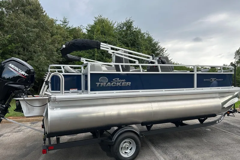 Slide: The Image of 2026 Sun Tracker Bass Buggy 18 DLX pontoon boat on trailer, featuring Mercury outboard motor. - 3