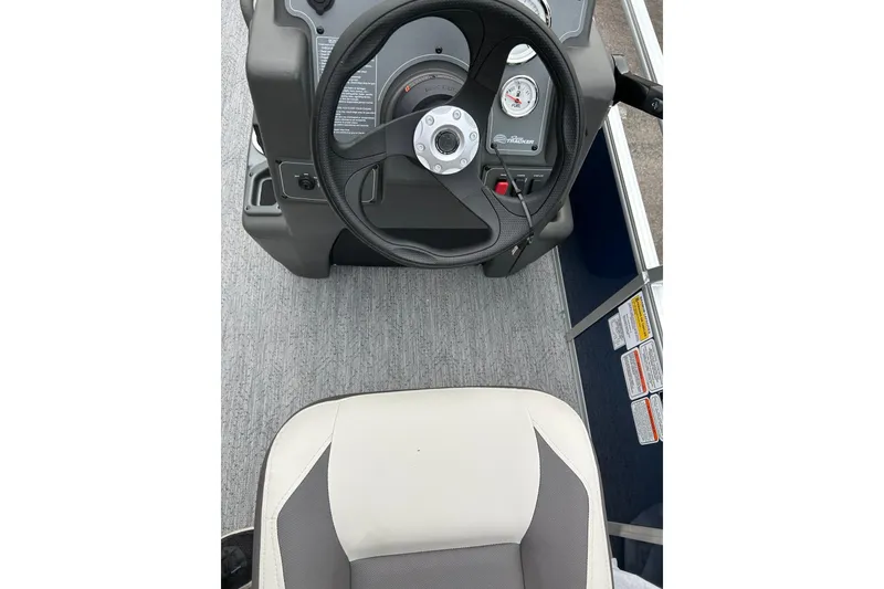 Slide: The Image of 2026 Sun Tracker Bass Buggy 18 DLX steering console and seat, featuring modern controls. - 2