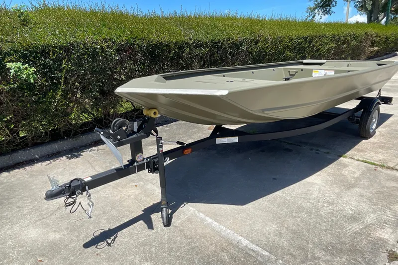 Slide: The Image of 2026 Tracker Grizzly 1648 Utility boat on trailer, parked outdoors on sunny day. - 5