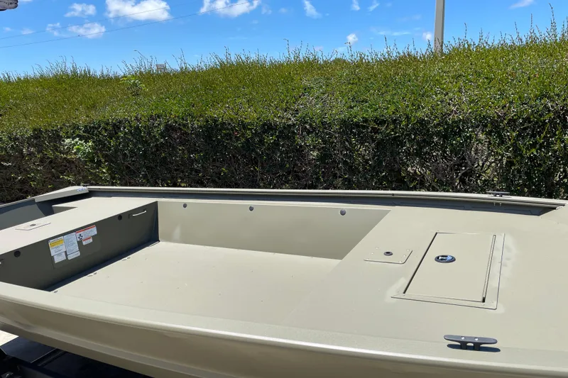 Slide: The Image of 2026 Tracker Grizzly 1648 Utility boat in a grassy outdoor setting under a blue sky. - 8