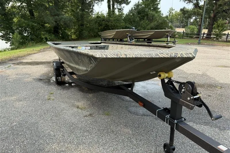 Slide: The Image of 2026 Tracker Grizzly 1648 Utility boat on trailer, parked outdoors near trees. - 5