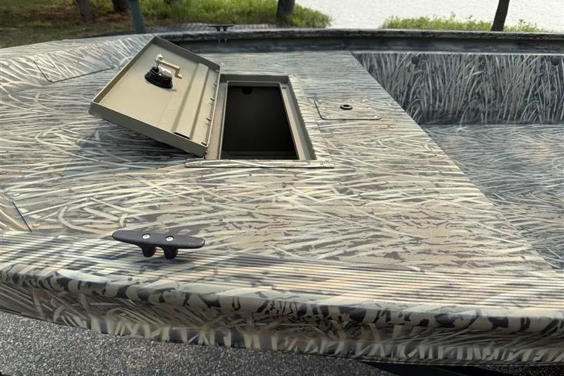 Slide: The Image of 2026 Tracker Grizzly 1648 Utility boat with open storage compartment, camo pattern. - 12