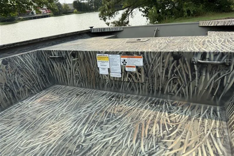 Slide: The Image of 2026 Tracker Grizzly 1648 Utility boat with camouflage pattern near a serene lake. - 11