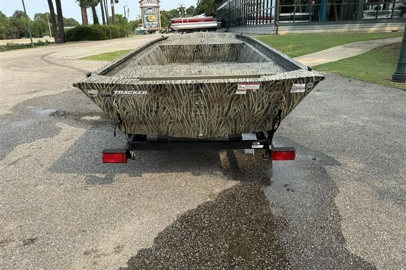 Slide: The Image of 2026 Tracker Grizzly 1648 Utility boat with camouflage design on a trailer. - 3