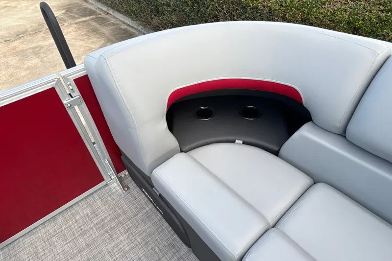 Slide: The Image of 2026 Sun Tracker Party Barge 22 RF DLX seating with cup holders, red and gray upholstery. - 13