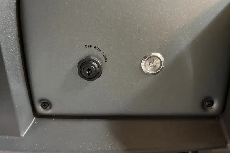 Slide: The Image of Control panel of 2026 Sun Tracker Party Barge 22 RF DLX with ignition switch and power button. - 23