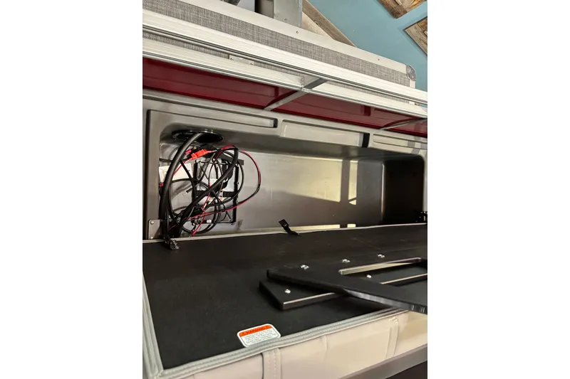 Slide: The Image of Interior view of 2026 Sun Tracker Party Barge 22 RF DLX with wiring and storage compartment. - 43