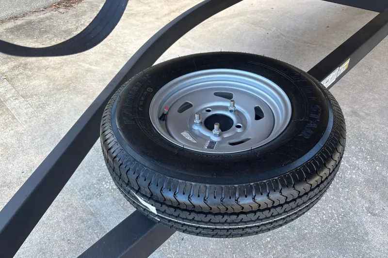 Slide: The Image of Spare tire mounted on a Sun Tracker Party Barge 22 RF DLX trailer, 2026 model. - 44