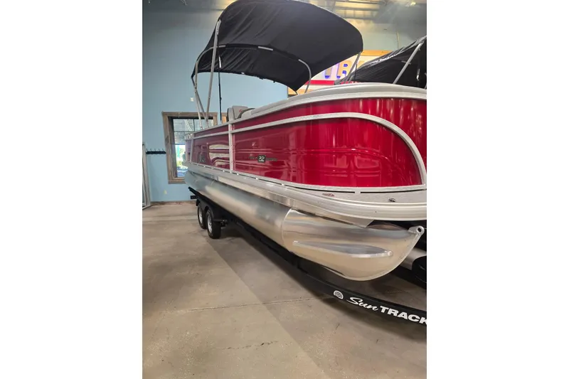 Slide: The Image of 2026 Sun Tracker Party Barge 22 RF DLX pontoon boat with red exterior and black canopy. - 1