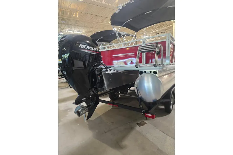 Slide: The Image of 2026 Sun Tracker Party Barge 22 RF DLX with Mercury outboard motor in showroom. - 2