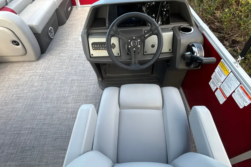 Slide: The Image of 2026 Sun Tracker Party Barge 22 RF DLX helm with steering wheel and seating. - 21