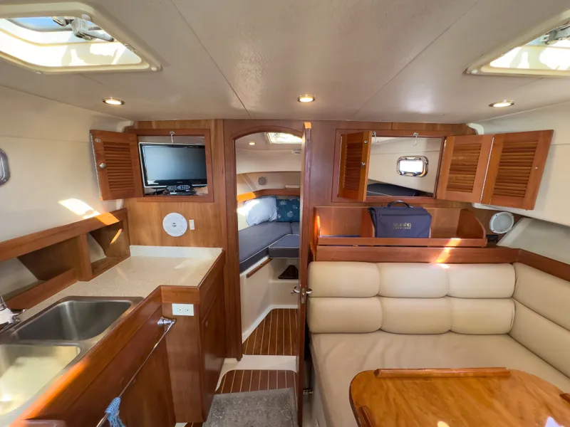 Slide: The Image of Interior of a 2004 Mainship Pilot 34 yacht with kitchen and seating area. - 17