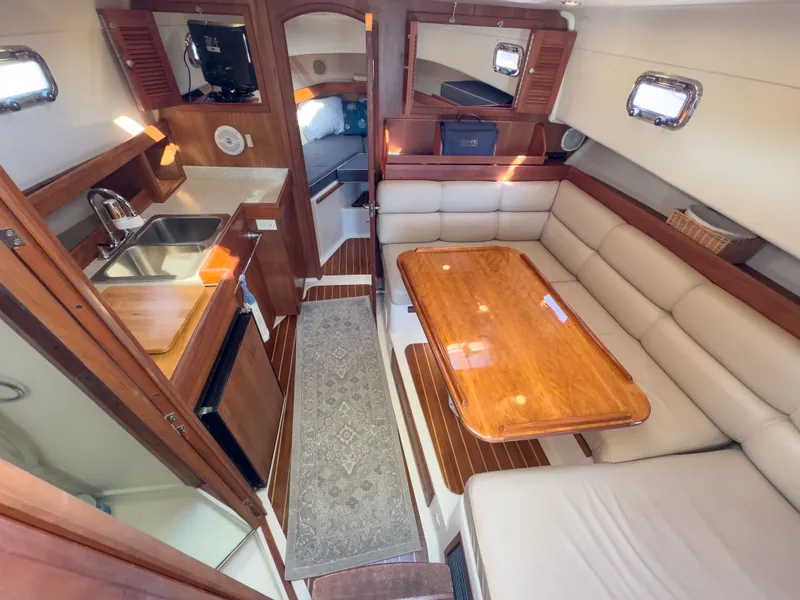 Slide: The Image of Interior of a 2004 Mainship Pilot 34 yacht, featuring kitchen and seating area. - 22