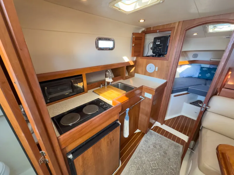 Slide: The Image of Interior of 2004 Mainship Pilot 34 yacht with kitchen and sleeping area. - 24