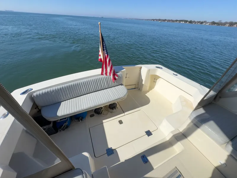 Slide: The Image of 2004 Mainship Pilot 34 boat with flag on calm water. - 3