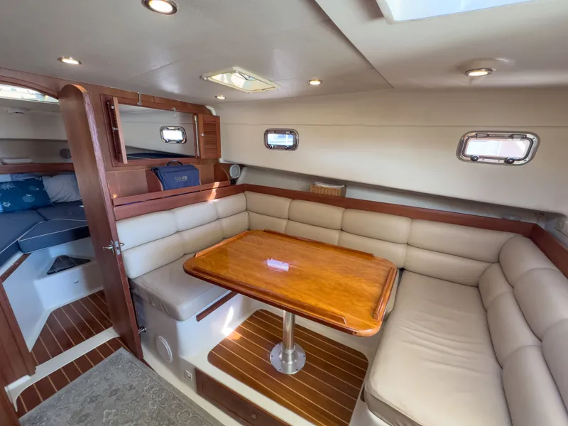 Slide: The Image of Interior of a 2004 Mainship Pilot 34 yacht with wood table and cushioned seating. - 31