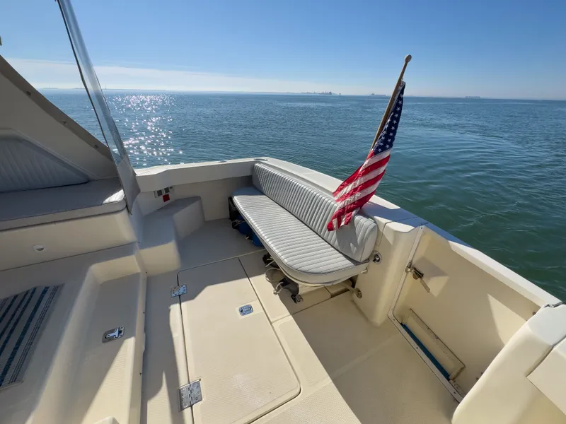 Slide: The Image of 2004 Mainship Pilot 34 boat with American flag on calm sea. - 4