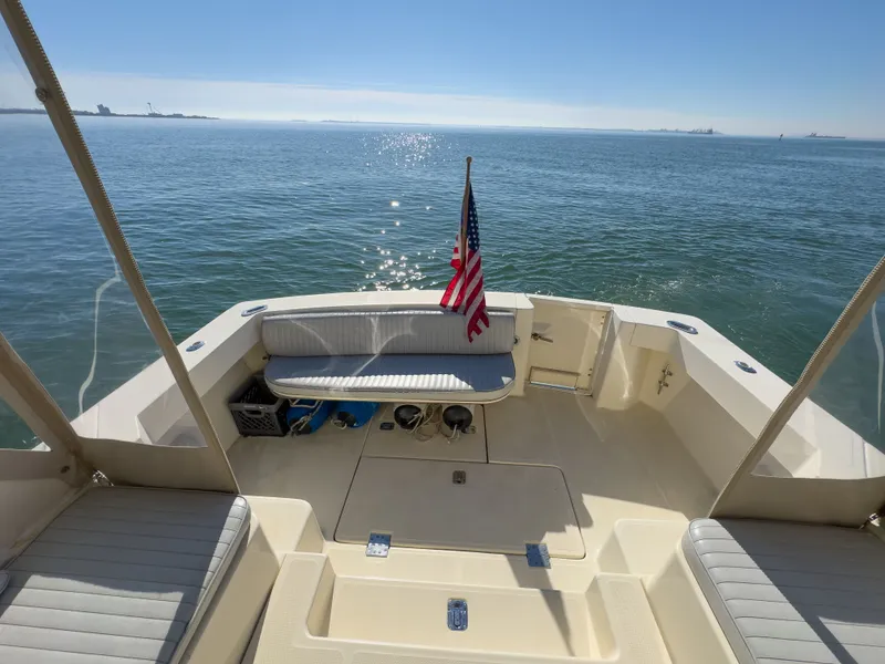 Slide: The Image of 2004 Mainship Pilot 34 boat on calm water with flag. - 5