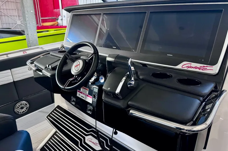 Slide: The Image of 2025 Cigarette 42' Auroris boat dashboard with steering wheel and digital displays. - 19