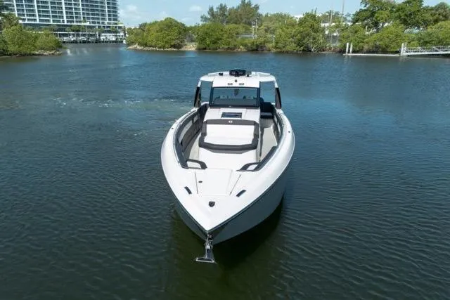 Slide: The Image of 2025 Cigarette 42' Auroris boat on calm water, surrounded by greenery. - 4