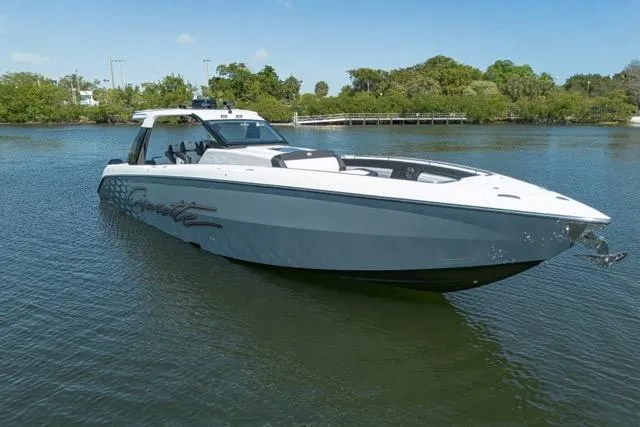 Slide: The Image of 2025 Cigarette 42' Auroris boat on calm water, surrounded by lush greenery. - 5