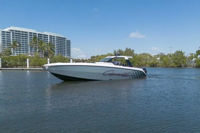 Slide: The Image of 2025 Cigarette 42' Auroris boat cruising on a calm waterway with buildings in the background. - 9