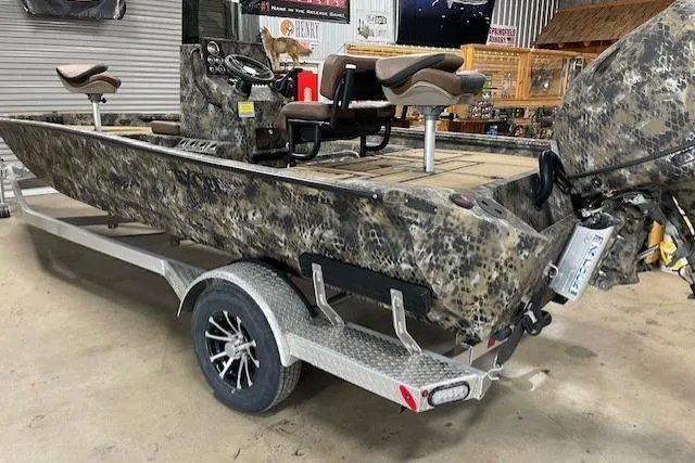 Slide: The Image of 2026 Excel 203 Bay Pro Elite boat with camouflage design on a trailer in a garage. - 10