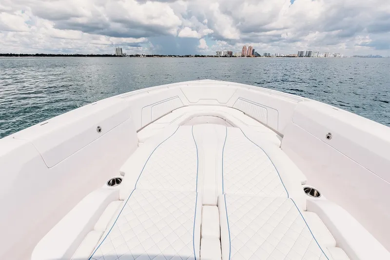 Slide: The Image of Manufacturer Provided Image: 2022 Intrepid 407 Nomad FE boat bow with white cushioned seating on open water. - 8