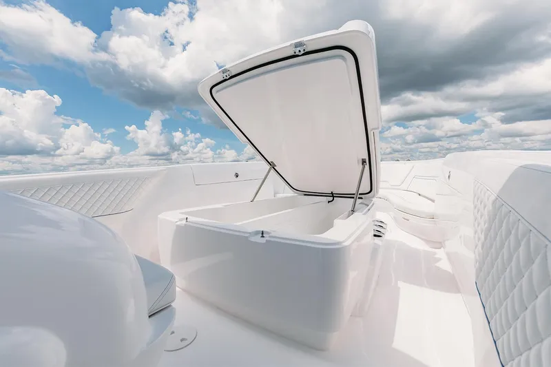 Slide: The Image of Manufacturer Provided Image: 2022 Intrepid 407 Nomad FE boat with open storage compartment under a cloudy sky. - 9