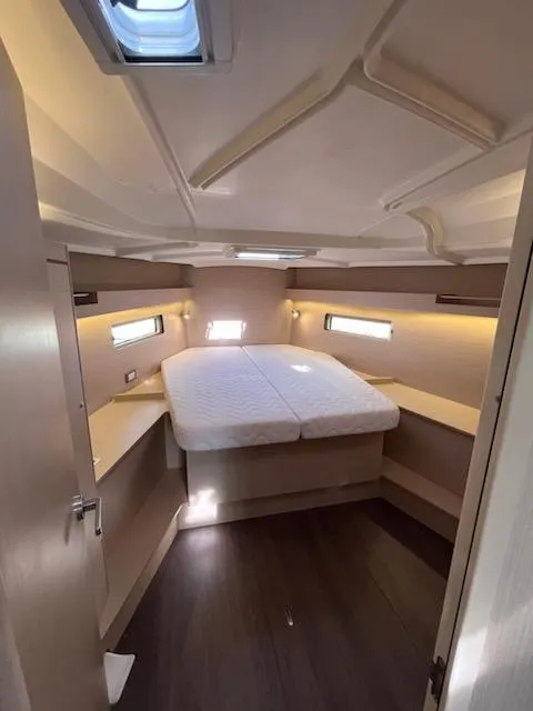 Slide: The Image of 2023 Beneteau Oceanis 40.1 cabin interior with bed, modern design, and ambient lighting. - 14