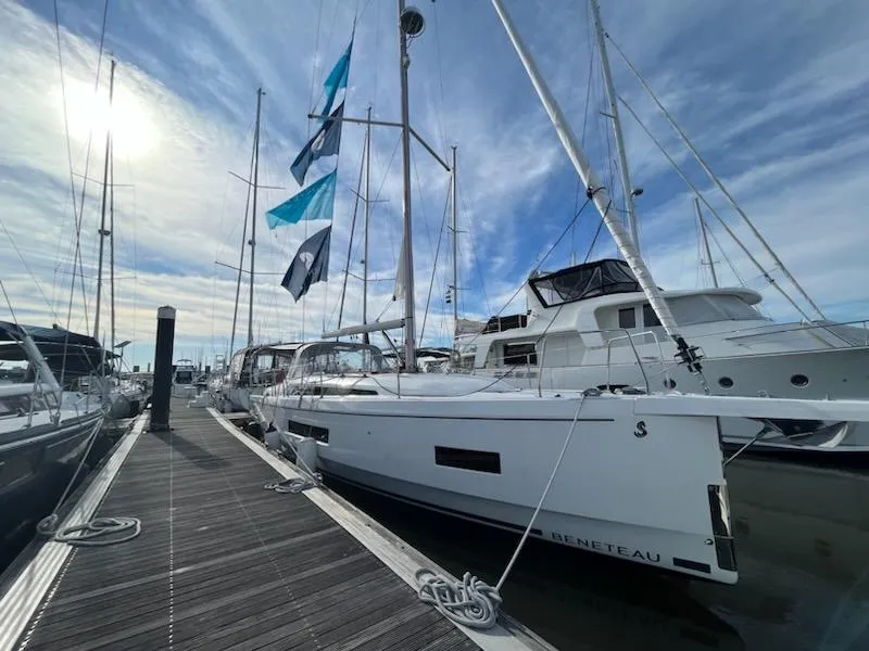 Slide: The Image of 2023 Beneteau Oceanis 40.1 sailboat docked under a clear sky. - 2
