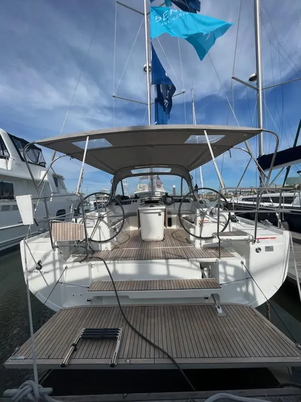 Slide: The Image of 2023 Beneteau Oceanis 40.1 sailboat docked, showcasing spacious deck and dual steering wheels. - 6