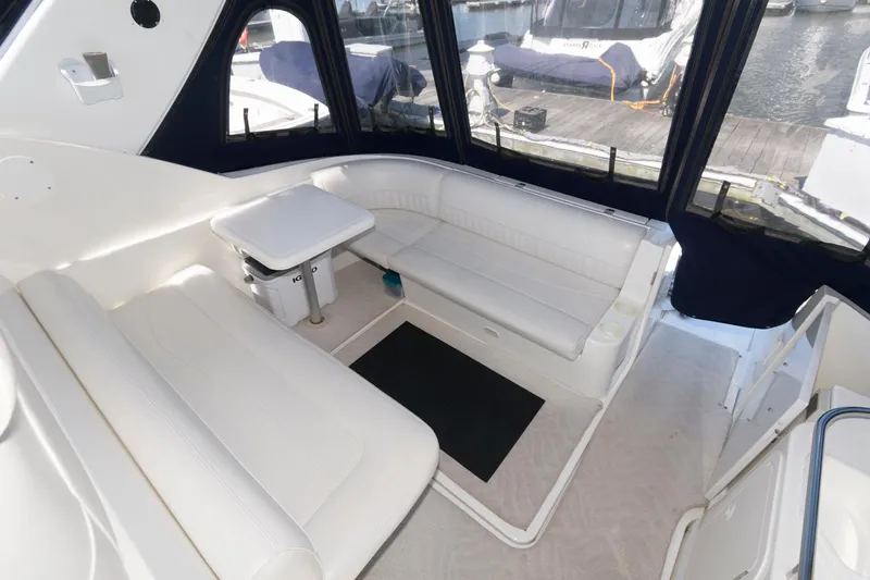 Slide: The Image of 2002 Cruisers Yachts 3275 Express interior seating area with white leather upholstery. - 7