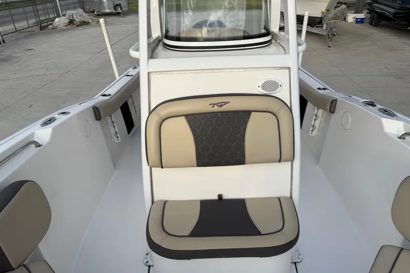 Slide: The Image of 2021 Tidewater 232 CC Adventure boat interior with cushioned seating and console. - 12