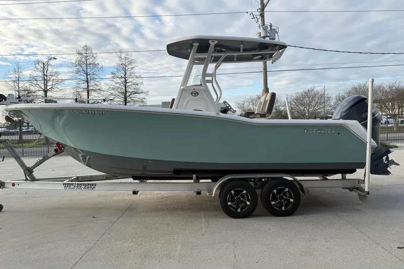 Slide: The Image of 2021 Tidewater 232 CC Adventure boat on trailer, parked outdoors under cloudy sky. - 5