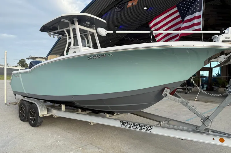 Slide: The Image of 2021 Tidewater 232 CC Adventure boat on trailer with American flag in background. - 7