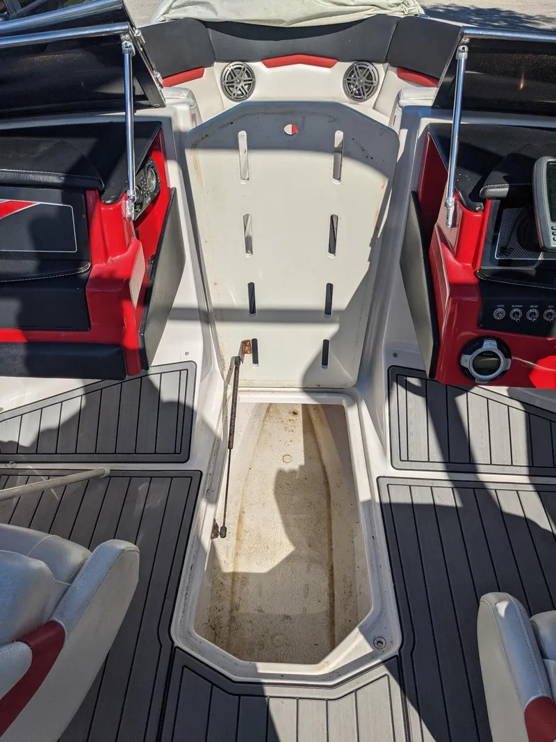 Slide: The Image of 2014 Four Winns H230SS boat interior with red and black accents, featuring a central storage compartment. - 6
