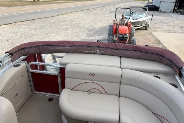 Slide: The Image of 2014 Avalon Catalina Cruise boat interior with beige seating, parked near a tractor. - 9