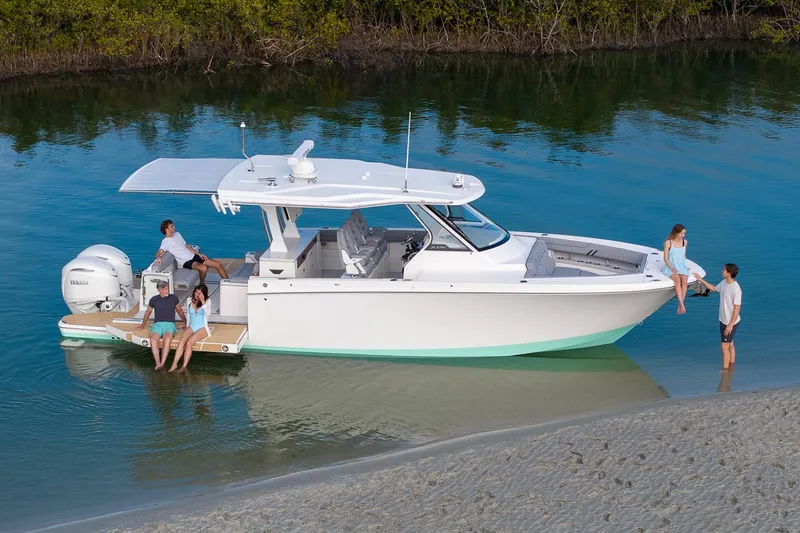 Slide: The Image of Manufacturer Provided Image: 2026 Regal 34 SAV boat with people relaxing on calm water near shore. - 2