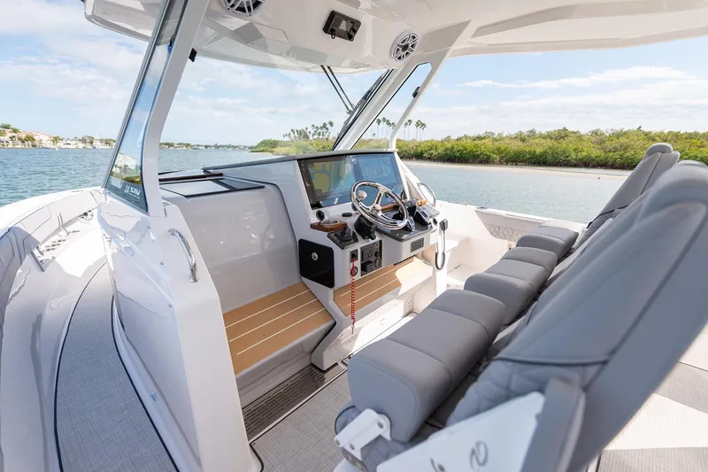 Slide: The Image of Manufacturer Provided Image: 2026 Regal 34 SAV boat interior with modern helm, plush seating, and scenic waterway view. - 8