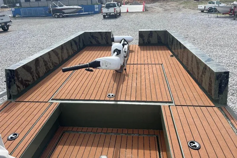 Slide: The Image of 2024 Other 1870 Bowfish boat with wooden deck and motor, parked on gravel. - 12