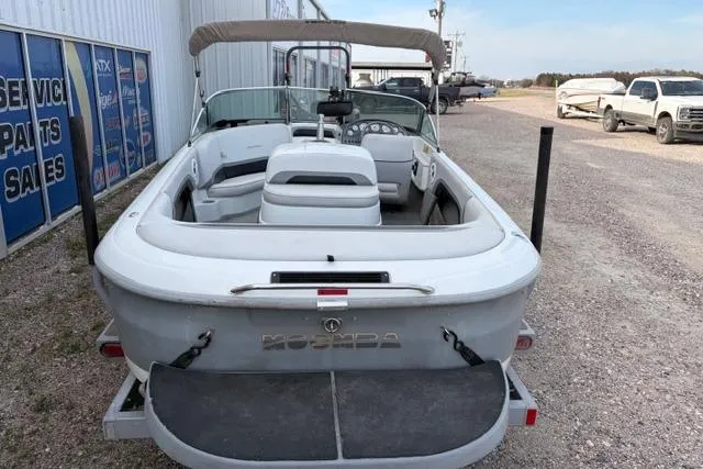 Slide: The Image of 2002 Moomba Outback boat, white exterior, parked outdoors near service center. - 5