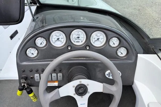 Slide: The Image of Dashboard of a 2002 Moomba Outback boat with gauges and steering wheel. - 6
