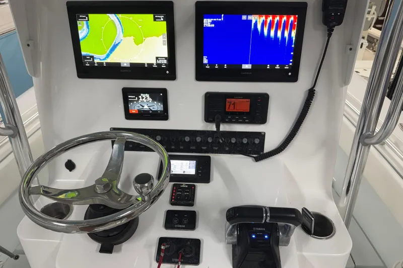 Slide: The Image of Control panel of a 2021 Contender 25 Tournament boat with navigation screens and steering wheel. - 13