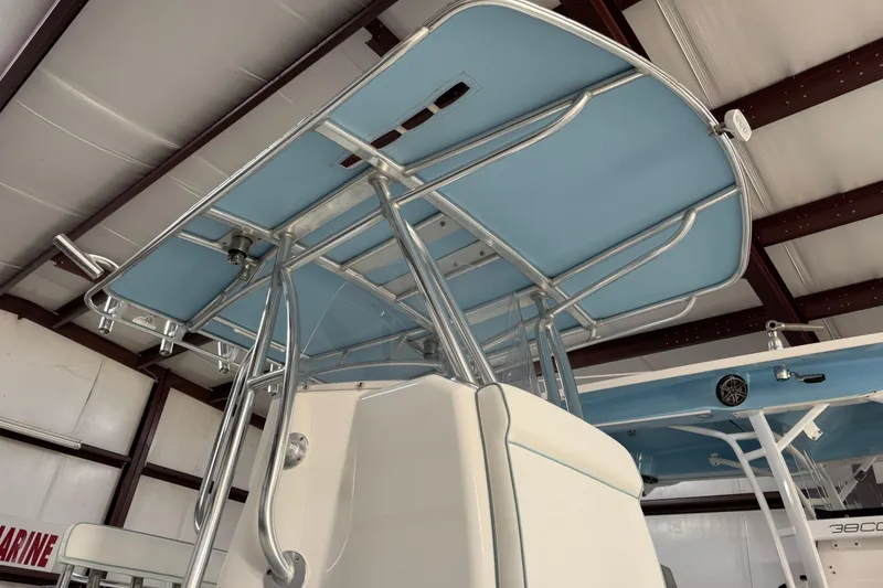 Slide: The Image of 2021 Contender 25 Tournament boat with blue T-top in a warehouse setting. - 2