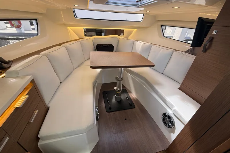Slide: The Image of 2022 Jeanneau Leader 10.5 WA Series 2 cabin with white seating and wooden table. - 19
