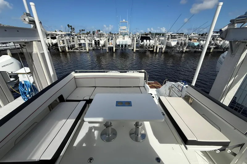 Slide: The Image of 2022 Jeanneau Leader 10.5 WA Series 2 boat interior with seating and table, docked at marina. - 7