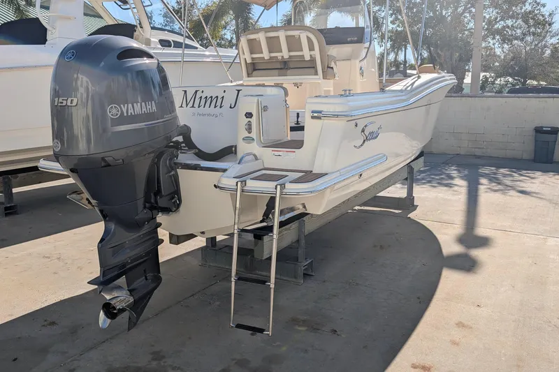 Slide: The Image of 2019 Scout 215 XSF boat with Yamaha 150 engine, docked outdoors. - 10