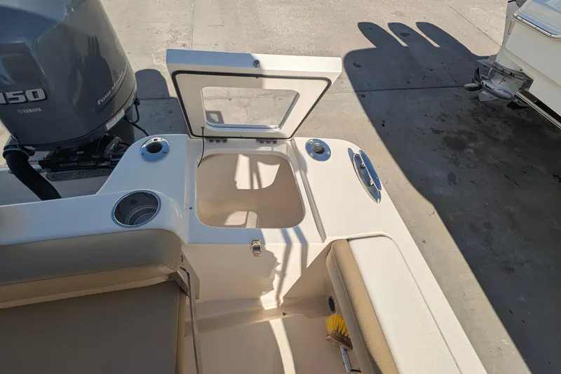 Slide: The Image of 2019 Scout 215 XSF boat interior with open storage compartment and Yamaha engine. - 16