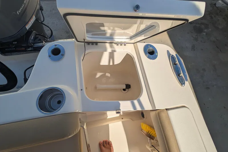 Slide: The Image of 2019 Scout 215 XSF boat interior with open storage compartment and engine view. - 17